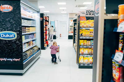 Rear view of people standing at store