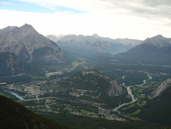 Scenic view of mountain range against cloudy sky