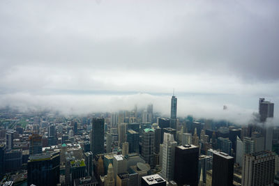 Aerial view of buildings in city against sky