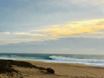 Scenic view of beach against sky during sunset