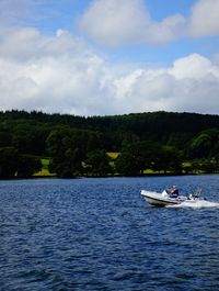 Man on boat in lake against sky