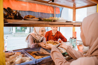 Shop keeper giving food to customer