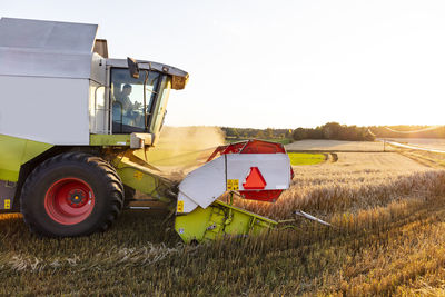 Combine harvester working in field