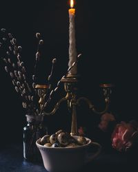 Close-up of lit candles on table against black background