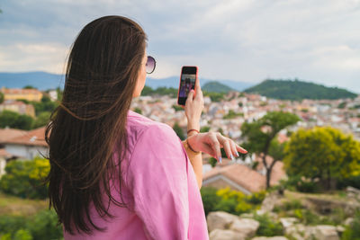 Rear view of woman photographing outdoors