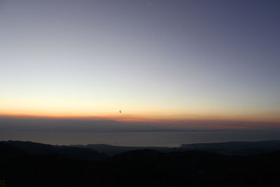 Scenic view of silhouette mountains against sky at sunset