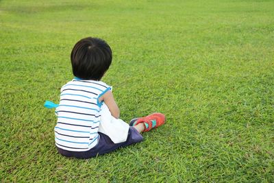 The asian little boy hugging a cloth bag on the lawn