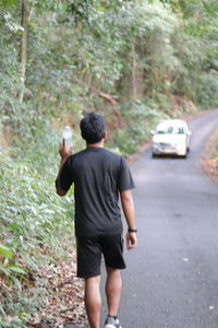 Rear view of man standing on road