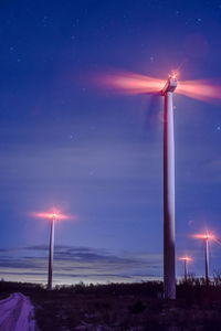 Wind turbines against sky at night