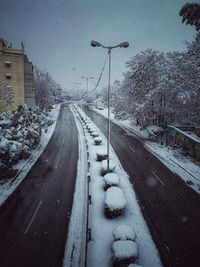 Road amidst snow covered city against sky