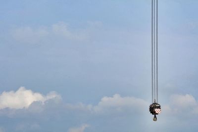 Low angle view of crane hook against sky