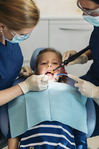 Dentists examining patient mouth in medical clinic