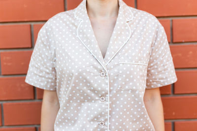 Midsection of woman standing against yellow wall