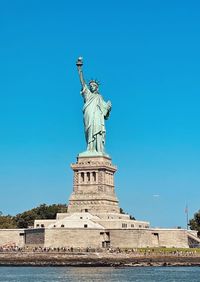 Low angle view of statue against clear blue sky