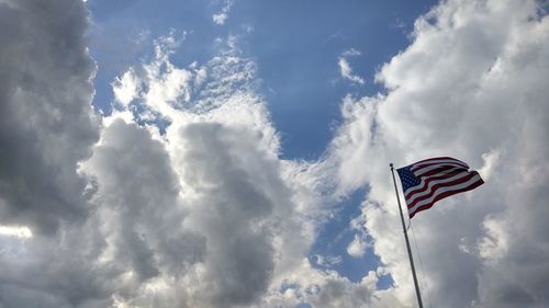 Low angle view of american flag against cloudy sky