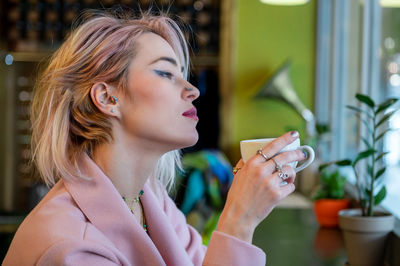 Young woman is drinking coffee in a cafe.