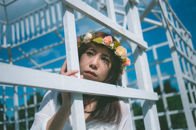 Woman looking away by metallic built structure