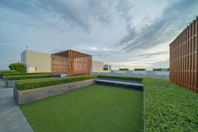 Lawn by building against sky