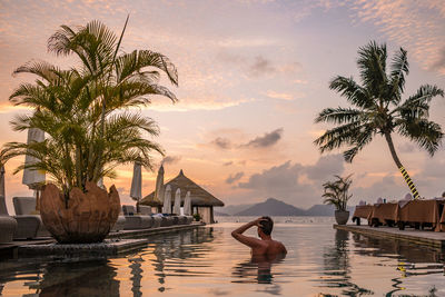 Man swimming in infinity pool against sky