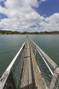 Jetty by lake against sky