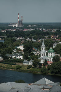 Buildings by sea against sky