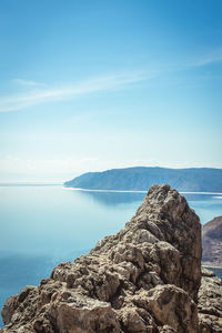 Scenic view of sea and mountains against clear blue sky