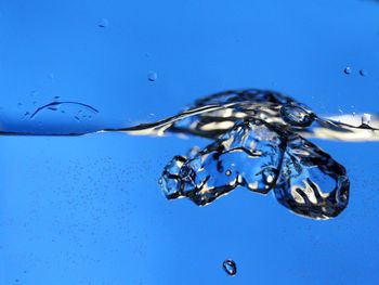 Close-up of splashing water against blue background