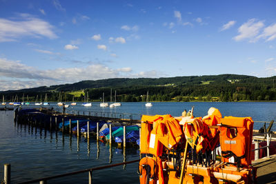 Boats moored in lake against sky