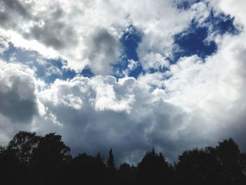 Low angle view of silhouette trees against sky