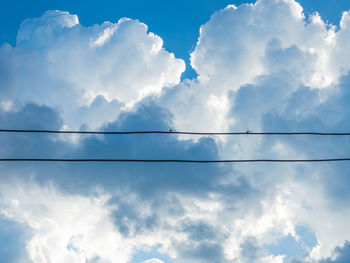 Low angle view of power lines against sky