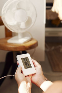 Woman holding thermostat at home