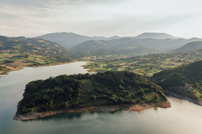 Scenic view of river and mountains against sky