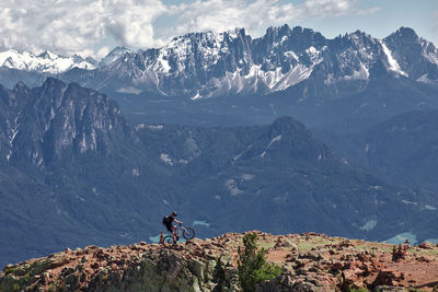 People on snowcapped mountain against sky