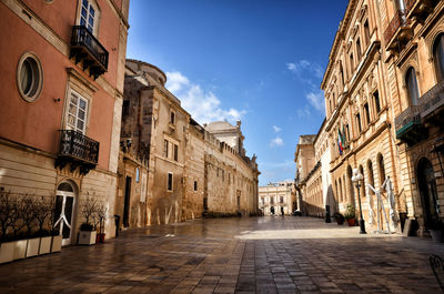 Street amidst buildings in town against sky