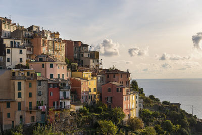 Corniglia landscape with colorfull tiny house on the sea at sunset