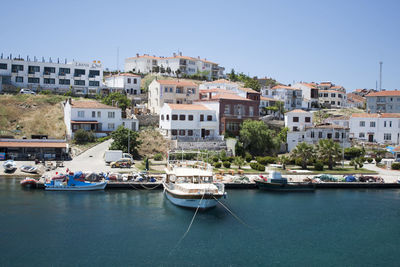 Boats moored at harbor against buildings in city