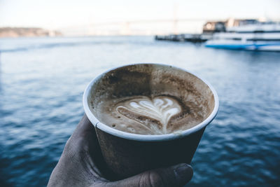 Close-up of hand holding coffee cup