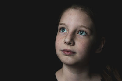 Portrait of a beautiful young woman over black background