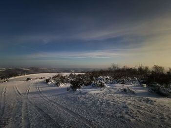 Snow covered land against sky