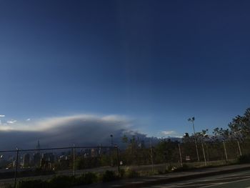 Road in city against blue sky