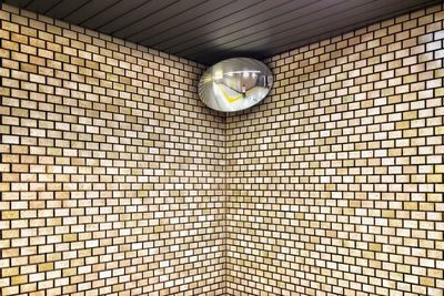 Low angle view of light bulbs hanging on wall