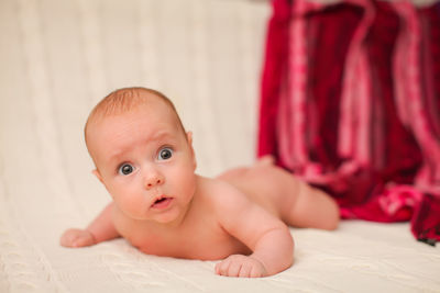 Portrait of cute baby lying on bed