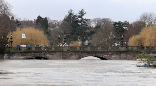 Arch bridge over river against sky