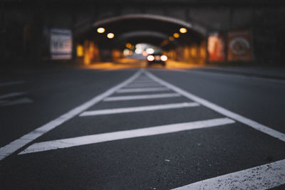 Close-up of zebra crossing on road at night