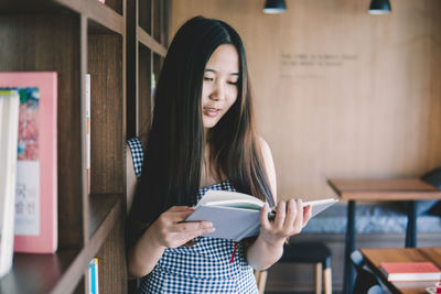 Portrait of young woman holding book