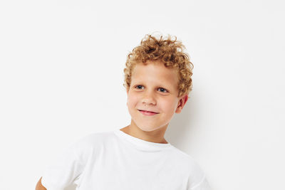 Boy looking away against white background