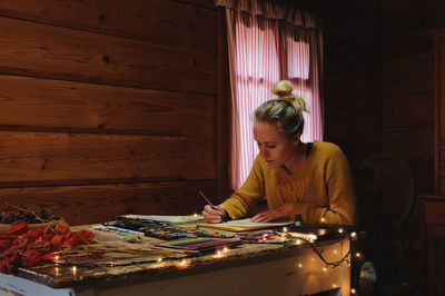 Woman drawing while sitting at table