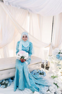 Bride wearing blue wedding dress sitting at stage