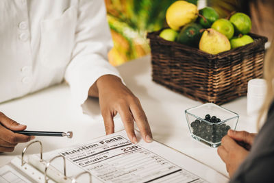 Nutritionist explaining nutrition facts label to a client, close-up