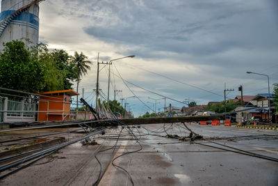 Railroad tracks by buildings in city against sky